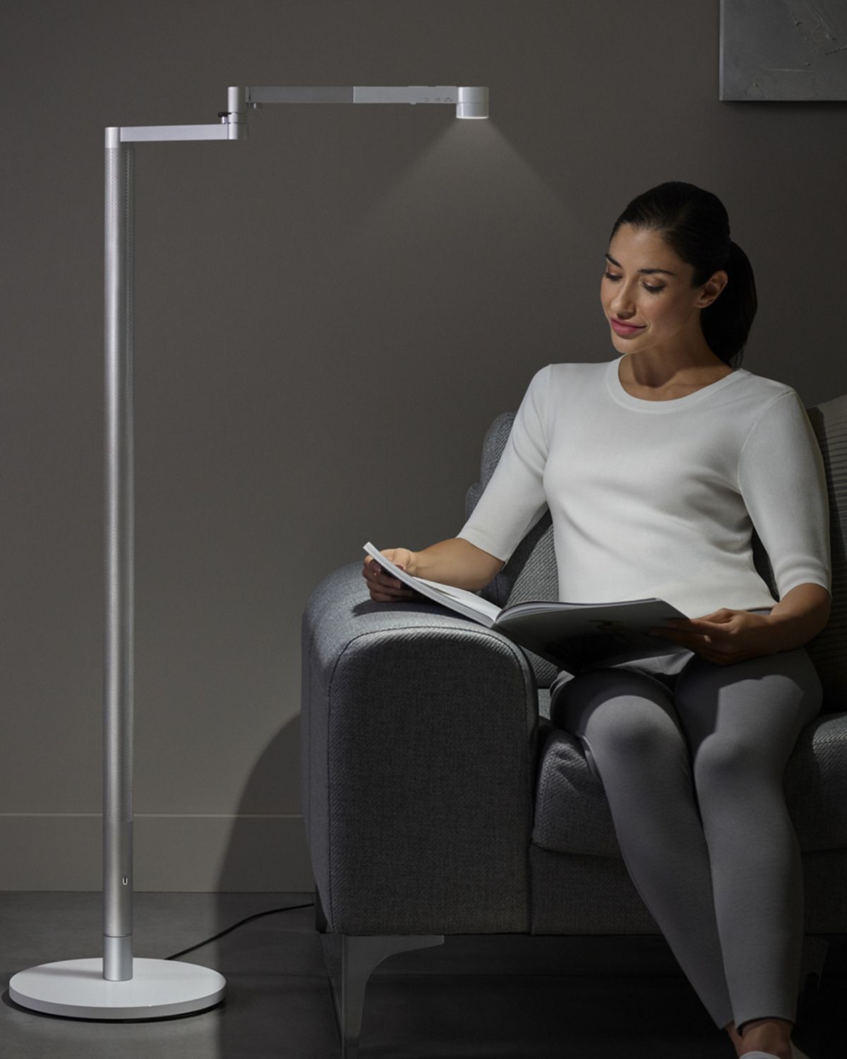 Woman reading under Dyson lightcycle morph.