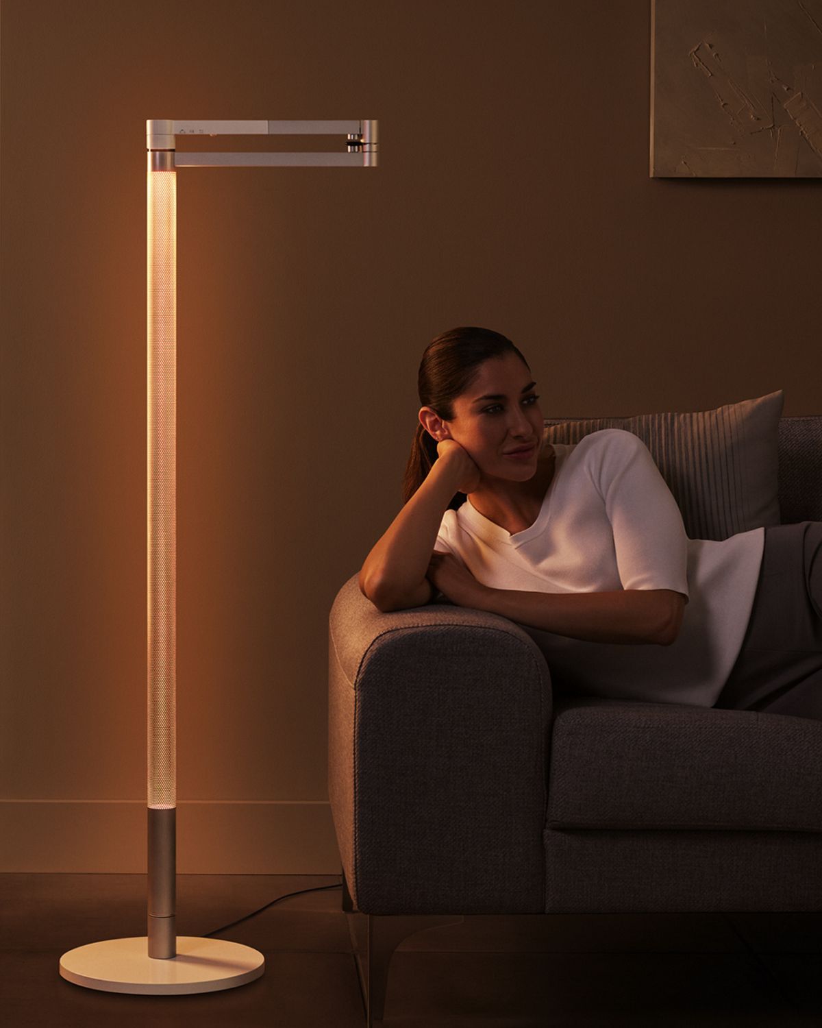 Woman relaxes as Dyson lightcycle morph gives off warm glow.