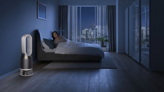 Frau im Bett schaltet den Dyson Pure Humidify and Cool™ mit der Fernbedienung ab.