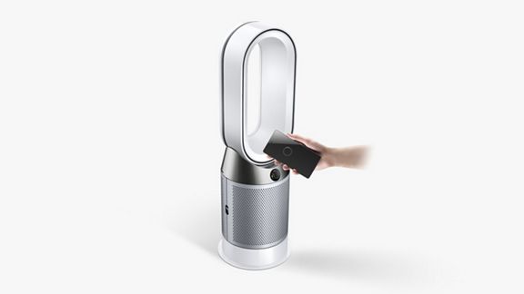 Ein Dyson Hot+Cool™ Luftreiniger steht auf einem Tisch und ein Smartphone zeigt die Dyson Link App.