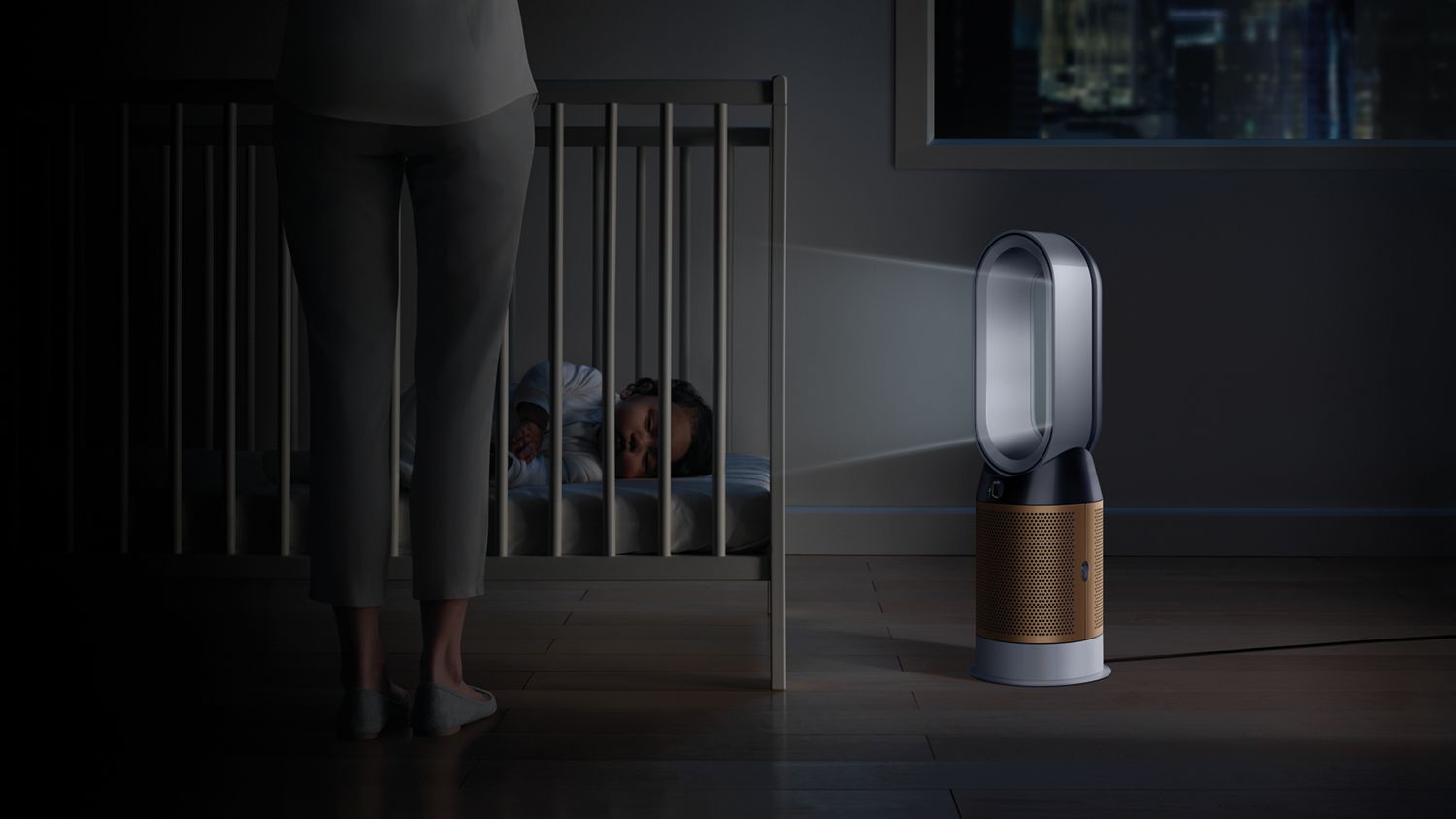 Der Pure Hot+Cool Cryptomic™ Luftreiniger steht in einem abgedunkelten Kinderzimmer, während im Hintergrund ein Baby schläft. 