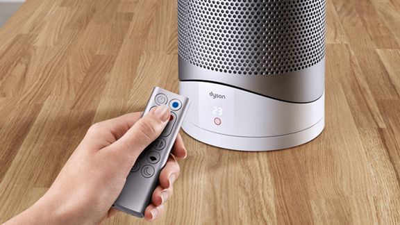 Un utente controlla il purificatore termoventilatore Dyson Pure Hot + Cool con il loro telecomando.