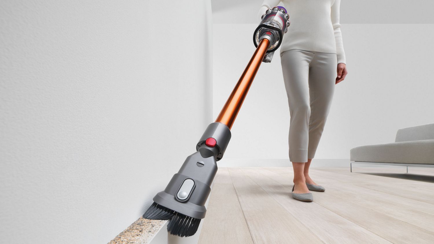 Dyson V10™ Absolute Pro kabelloser Staubsauger wird zum Entfernen von Schmutz aus einem schwierig zu erreichenden Bereich verwendet.