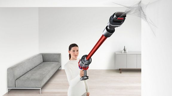 Ein Dyson V10™ Motorhead kabelloser Staubsauger entfernt Spinngewebe von einer schwierig zu erreichenden Stelle an der Decke