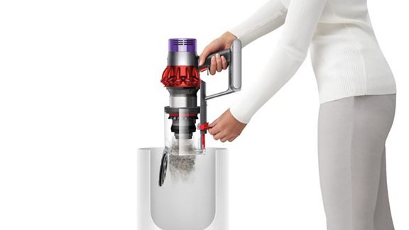 Dyson V10™ Motorhead kabelloser Staubsauger wird mithilfe des Systems zur punktgenauen Behälterentleerung in einen Mülleimer entleert.