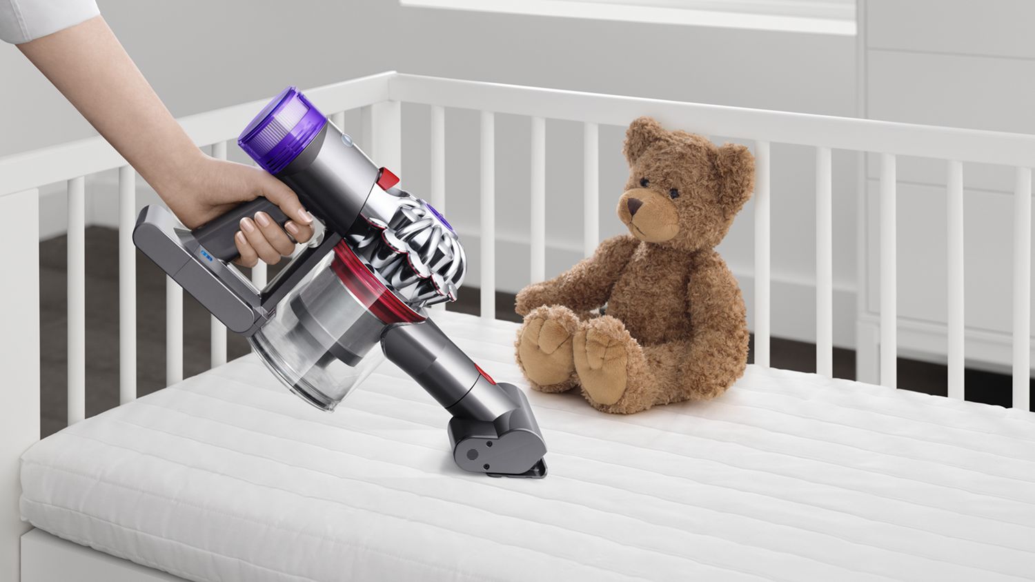 Aspirador sem fios Dyson V8 Absolute Pro limpa a sujidade da cómoda de um bebé.