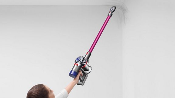 Dyson V8™ Absolute Pro kabelloser Staubsauger saugt unter Schubladen, um Staub zu entfernen.