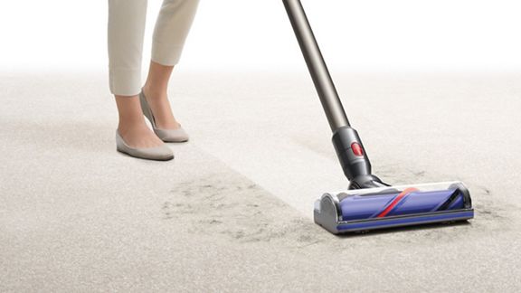 Ein Dyson V8™ Motorhead kabelloser Staubsauger entfernt Schmutz von Hartboden.
