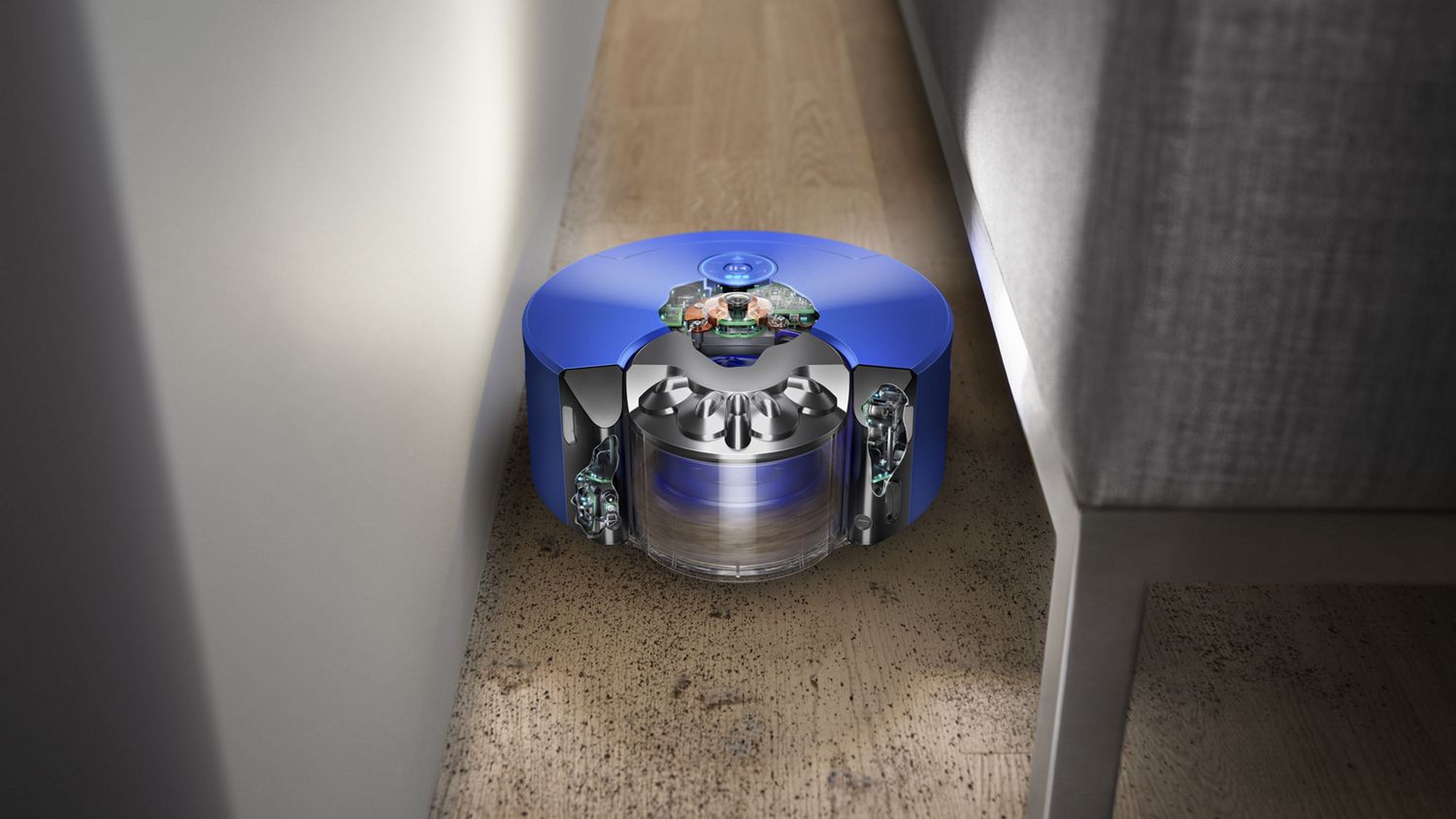 Robot aspirador Dyson 360 Heurist navega num espaço estreito entre o sofá e a parede.