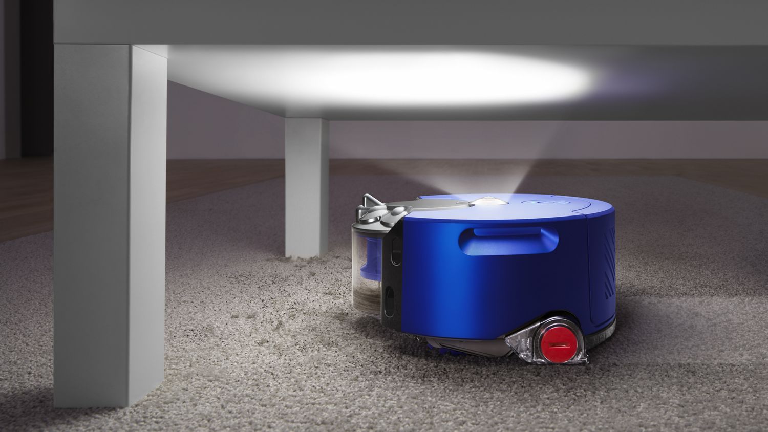 Robot aspirador Dyson 360 Heurist limpa independentemente passando debaixo de uma mesa de café.