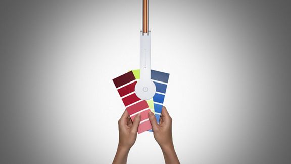 Un fascio di luce dall'alto per la modalità lavoro Dyson CSYS, illuminando qualcuno che tiene campioni di colore in mano.