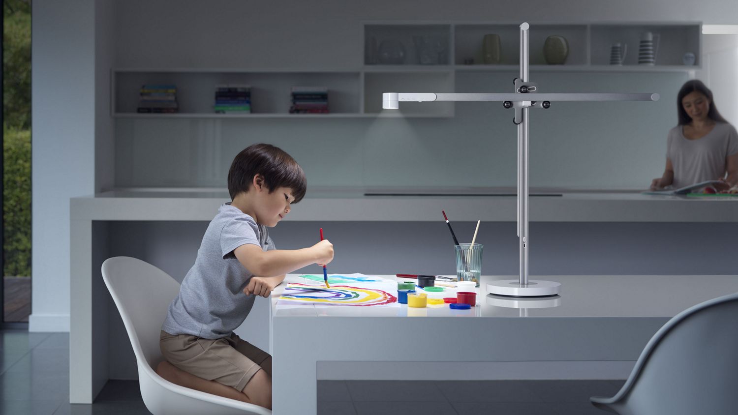 La lampe de bureau Dyson Solarcycle illuminant un espace de travail pour enfants.