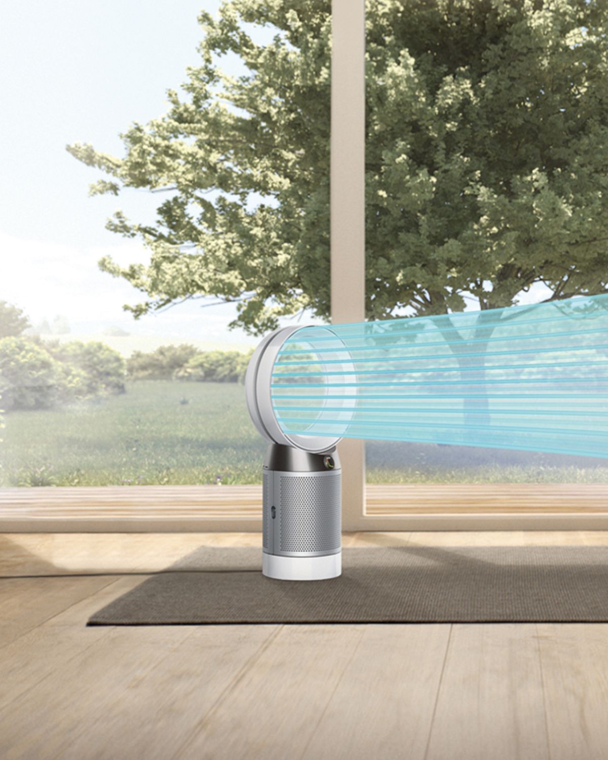 A woman sits on the sofa in a stream of blue air, projected from the Dyson Cool purifier fan. It's a sunny day outside. 