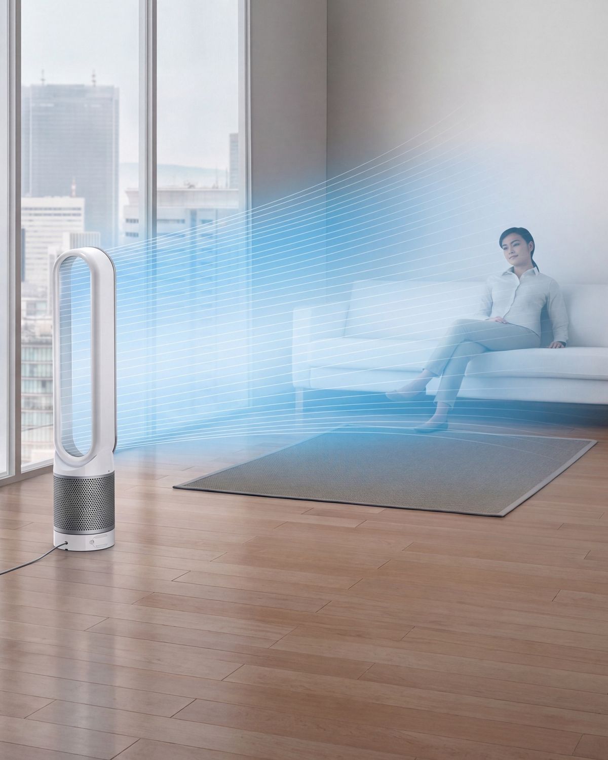 A woman sits on the sofa in a city apartment. A stream of blue, illustrating cool, purified air, projected from the Dyson Cool purifier fan onto her. 