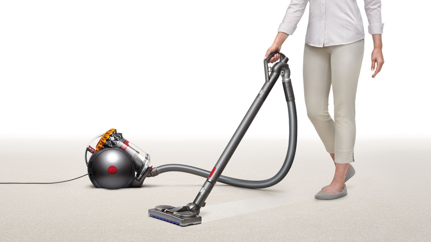 Dyson Big ball canister vacuum cleaner picking up debris from carpet.