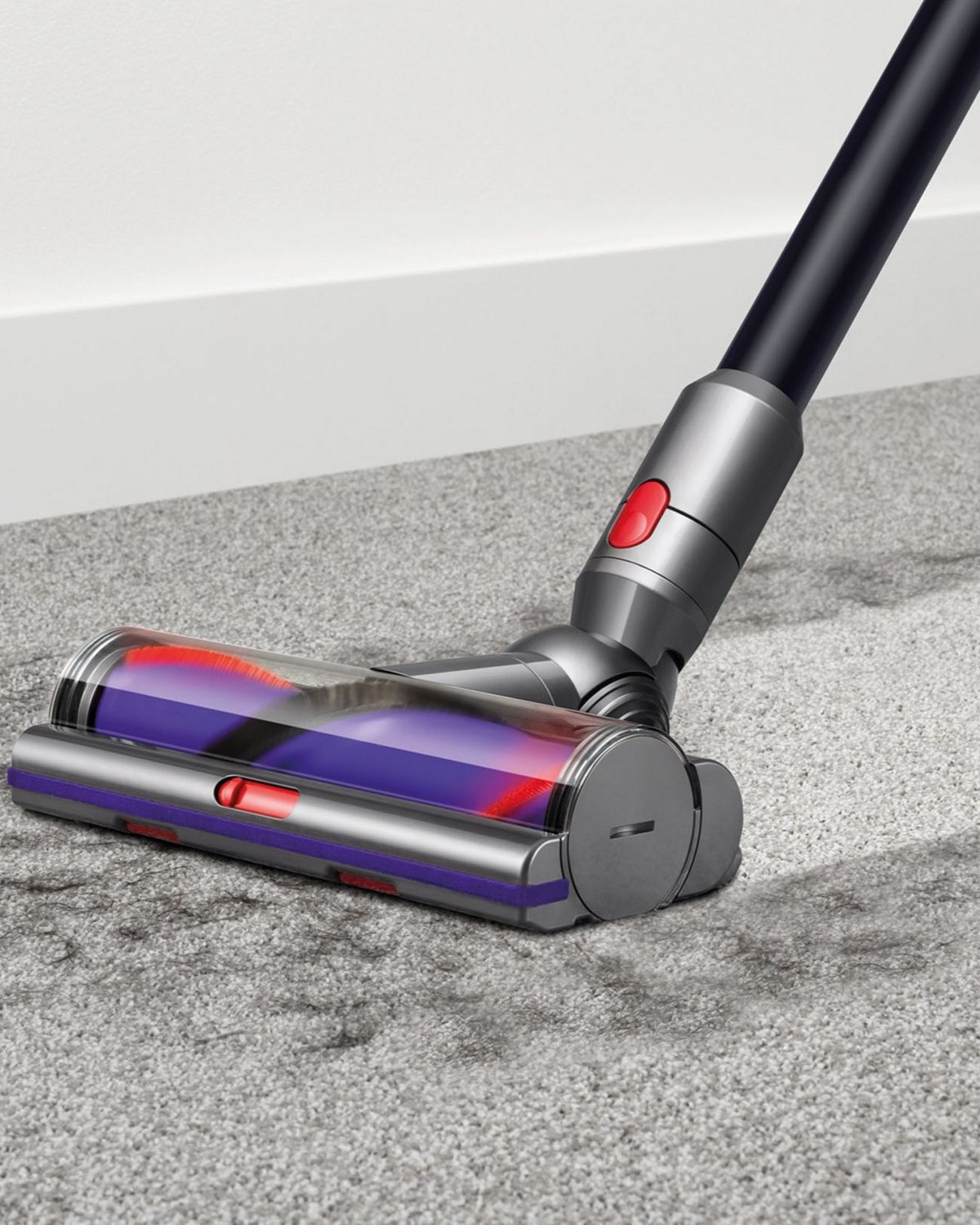 Woman using Dyson V10 Animal cordless vacuum cleaner to vacuum hard floor.