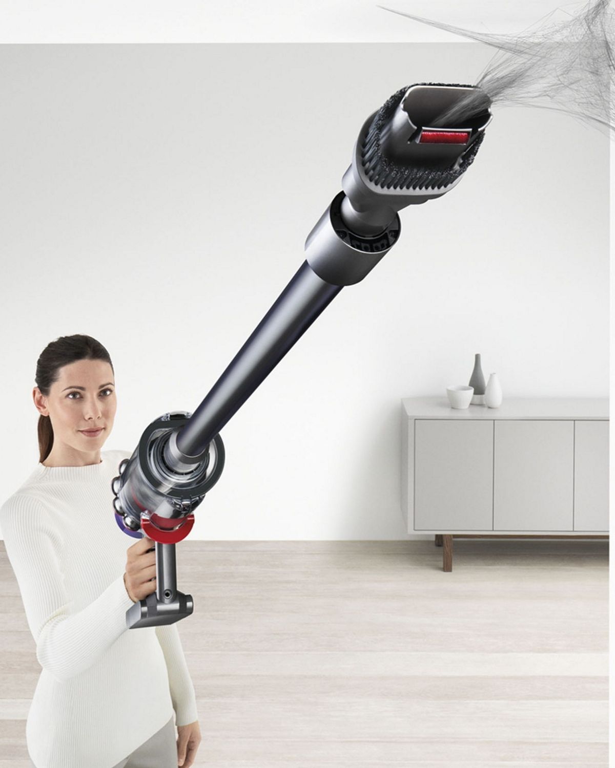 Dyson V10 Animal cordless vacuum being used to collect debris from hard to reach area.