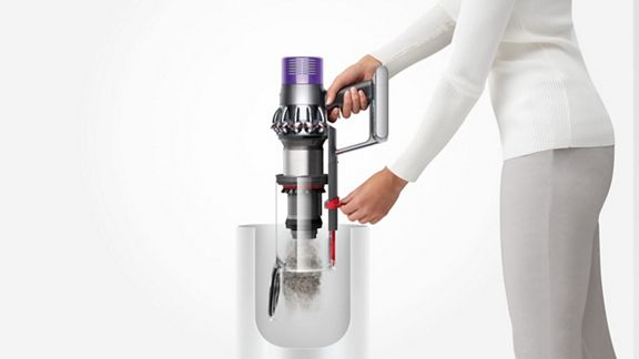 L'aspirateur sans fil Dyson V10 Animal est vidé dans la poubelle à l'aide du système de point et de pousse hygiénique.