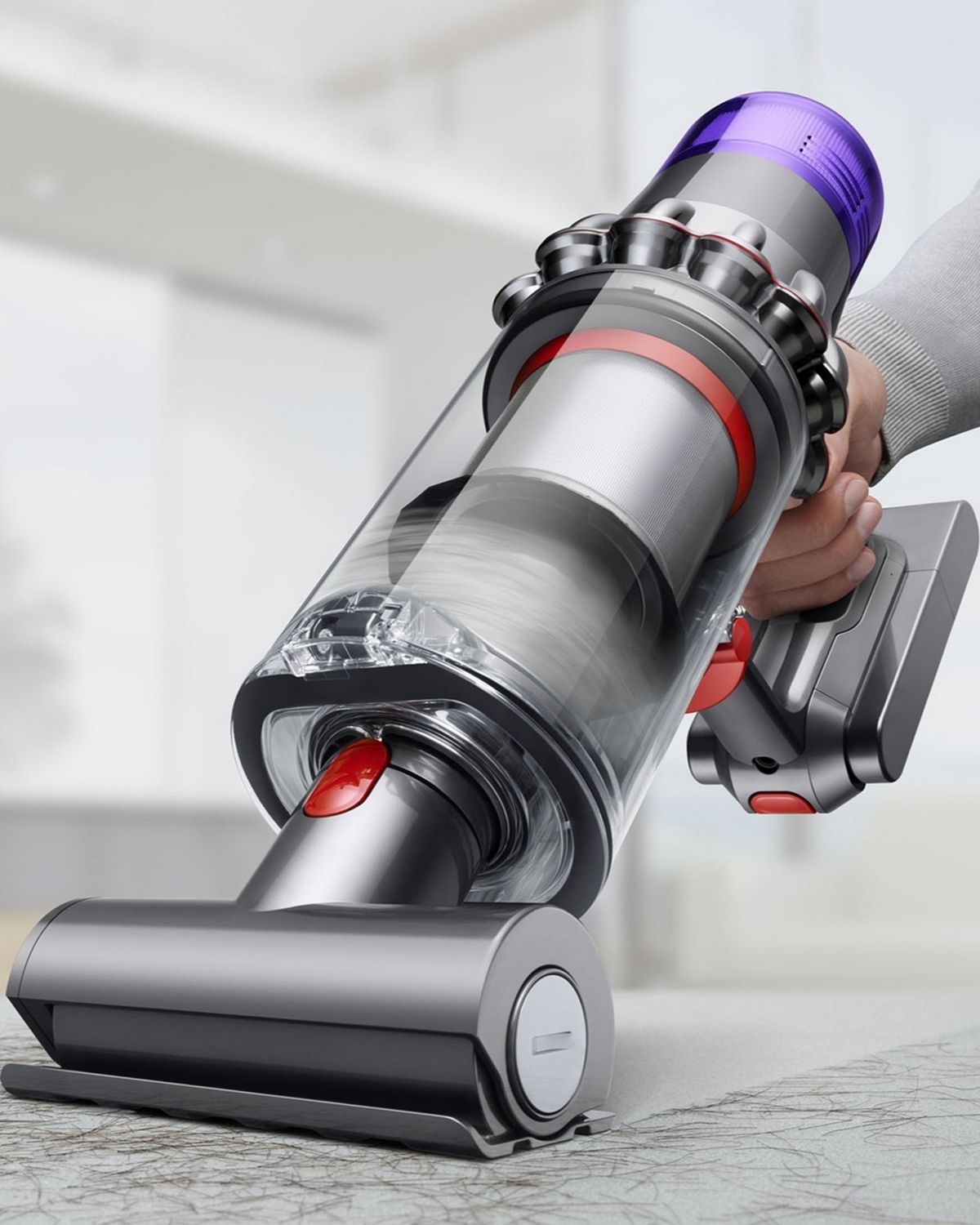 A Dyson V11 Animal cordless vacuum cleaner in handheld mode cleaning debris from upholstery