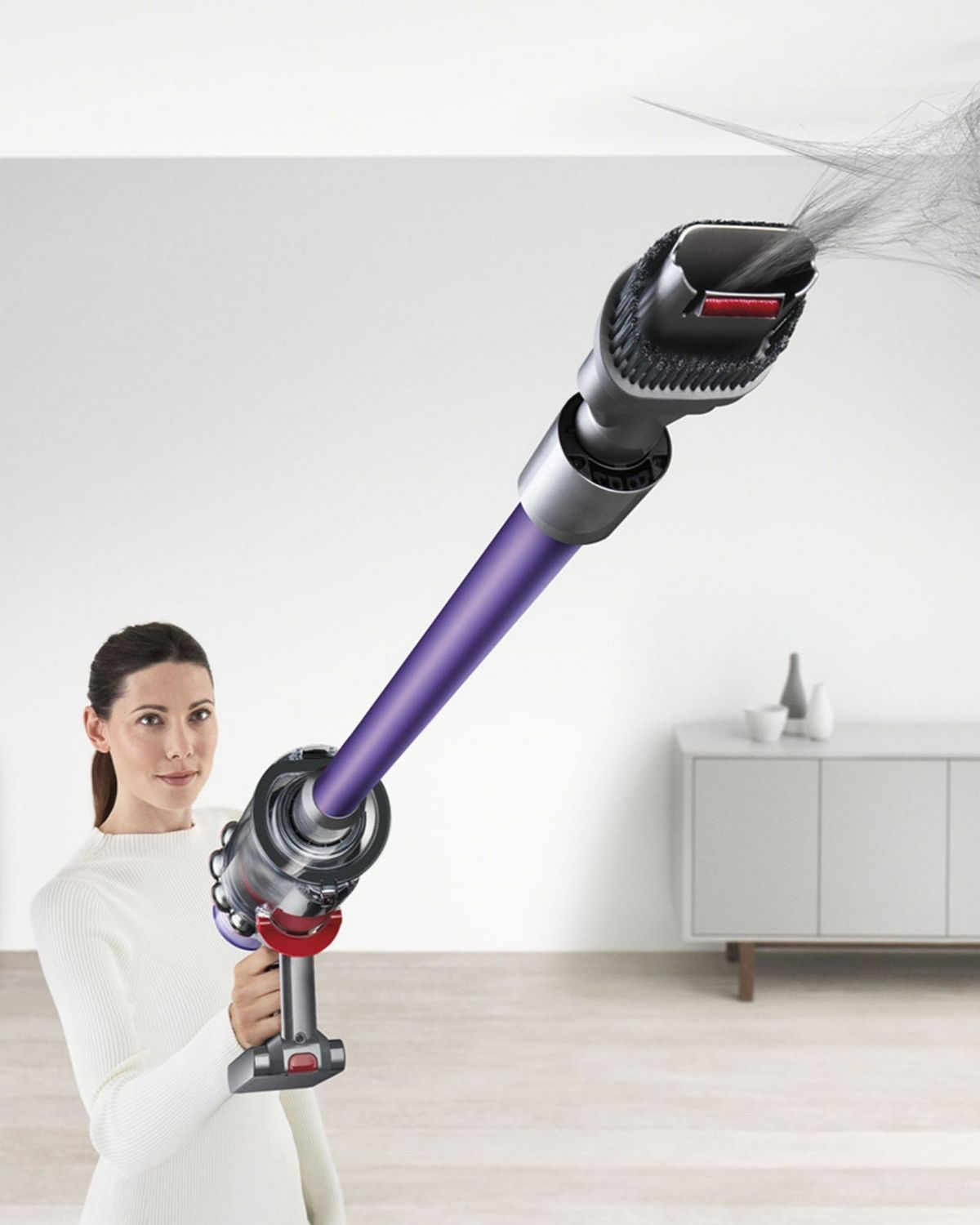 A Dyson V11 Animal cordless vacuum cleaner removing cobwebs from a hard-to-reach spot on the ceiling