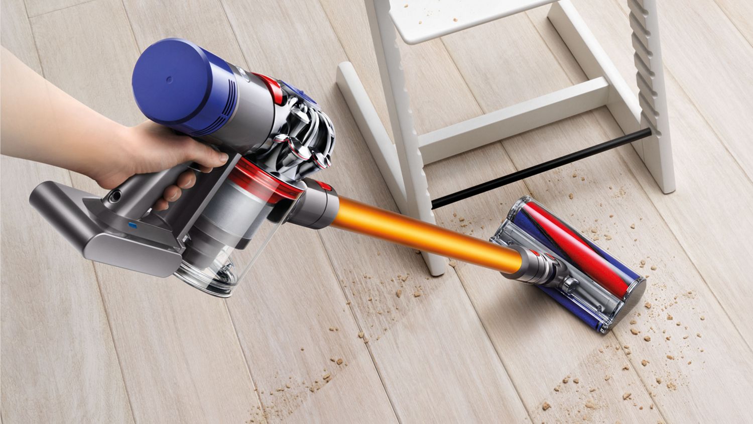 Dyson V8 Absolute cordless vacuum cleaner picking up debris from a hard floor. 
