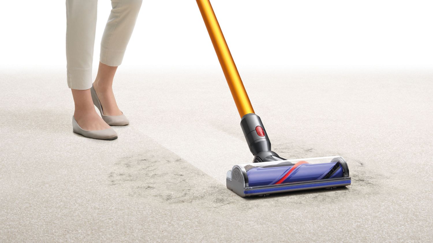 Dyson V8 Absolute cordless vacuum cleaner picking up debris from carpet. 