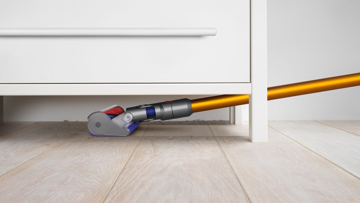 Dyson V8 Absolute cordless vacuum cleaner reaches under a set of drawers to tackle dust.