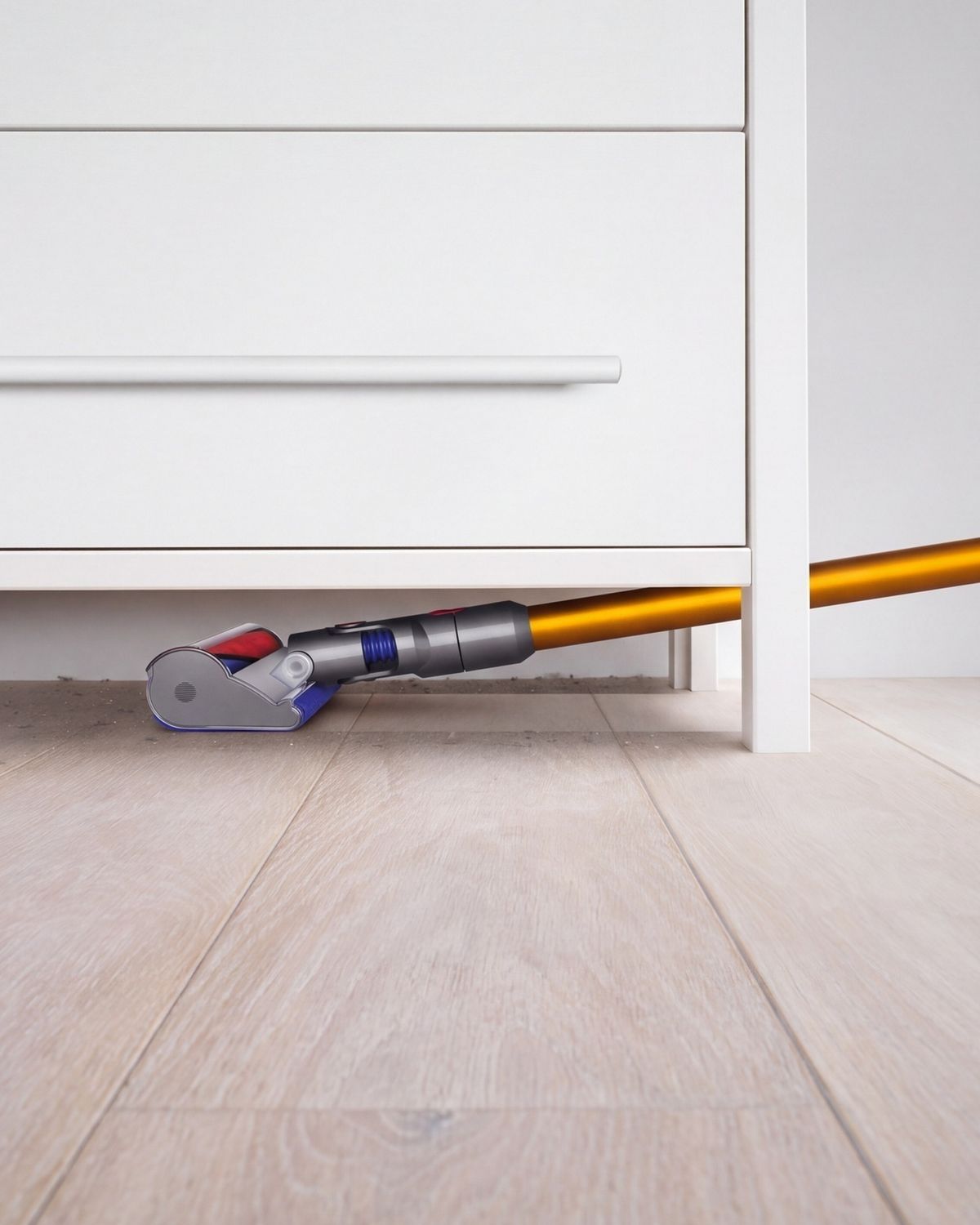 Dyson V8 Absolute cordless vacuum cleaner reaches under a set of drawers to tackle dust.