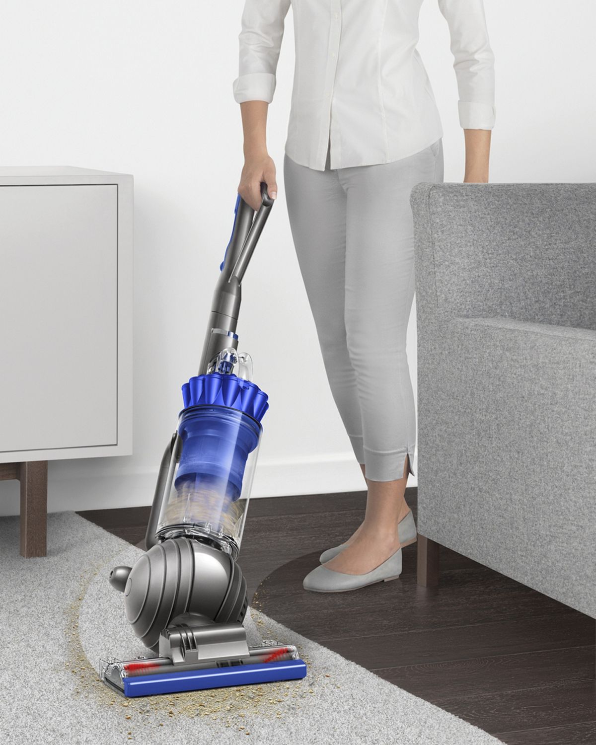 Dyson Ball Total Clean upright vacuum cleaner manoeuvring around furniture to clean floor.