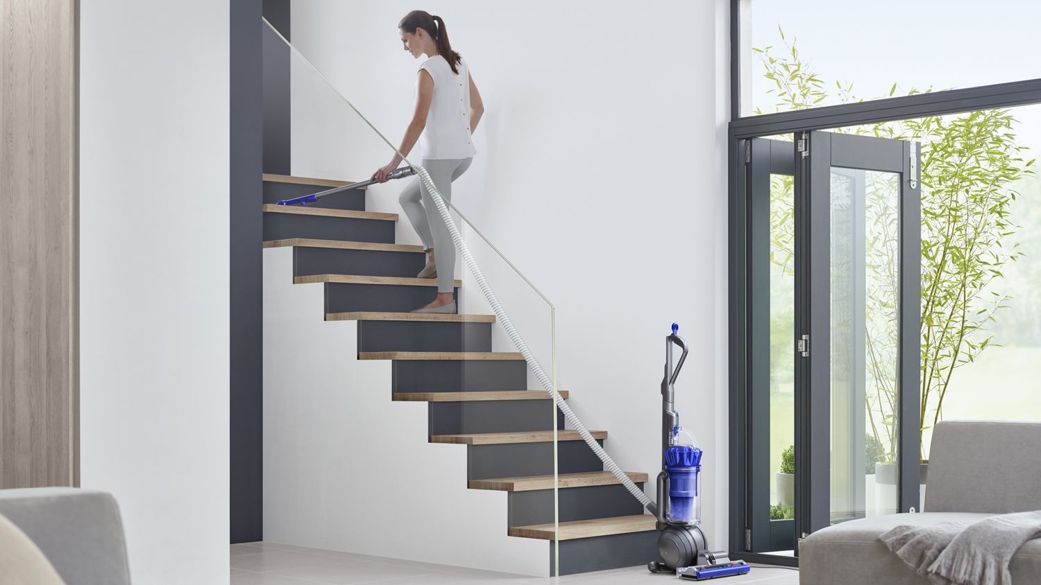 Dyson Ball Total Clean upright vacuum cleaner being used to clean stairs.