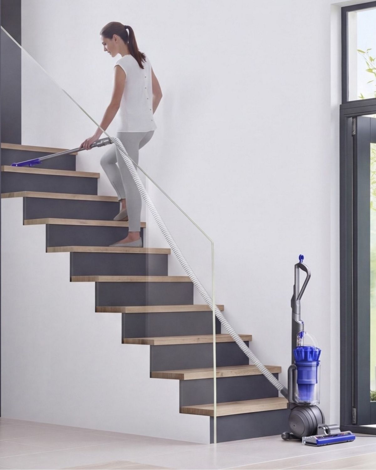 Dyson Ball Total Clean upright vacuum cleaner being used to clean stairs.