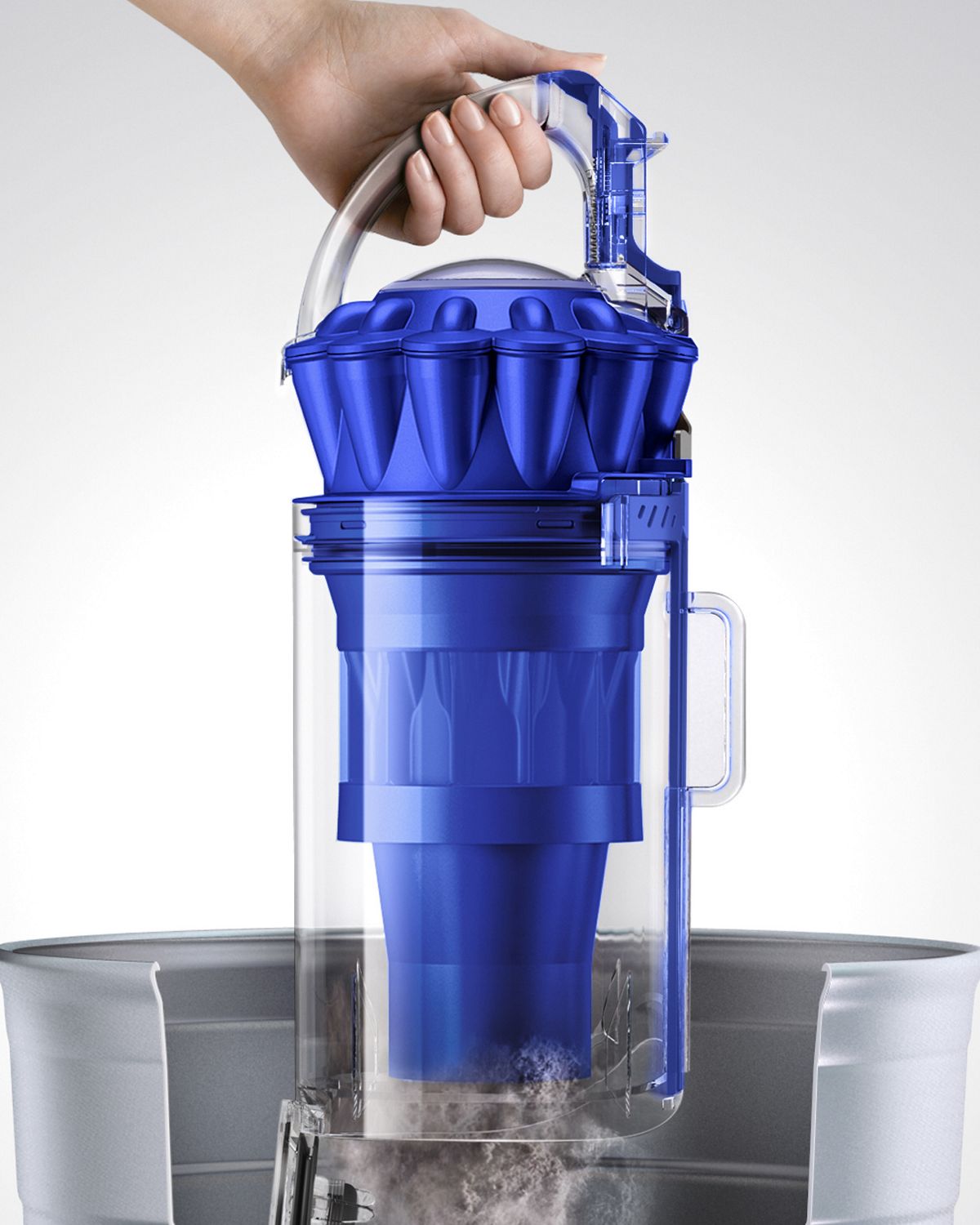 Dyson Ball Total Clean upright vacuum cleaner being emptied in a garbage bin with easy release system. 