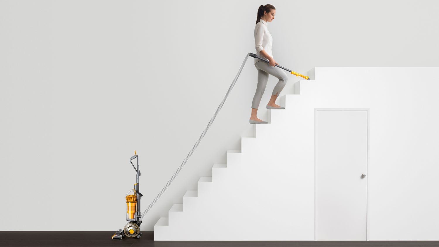 Dyson Ball Multifloor 2 upright vacuum cleaner being used to clean stairs.