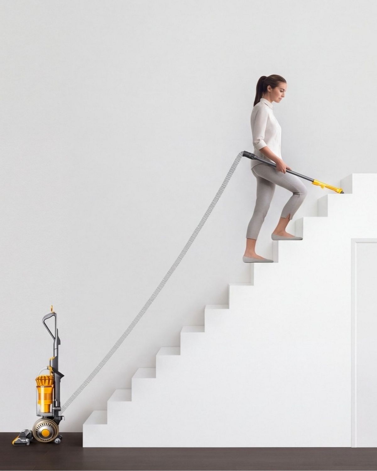 Dyson Ball Multifloor 2 upright vacuum cleaner being used to clean stairs.
