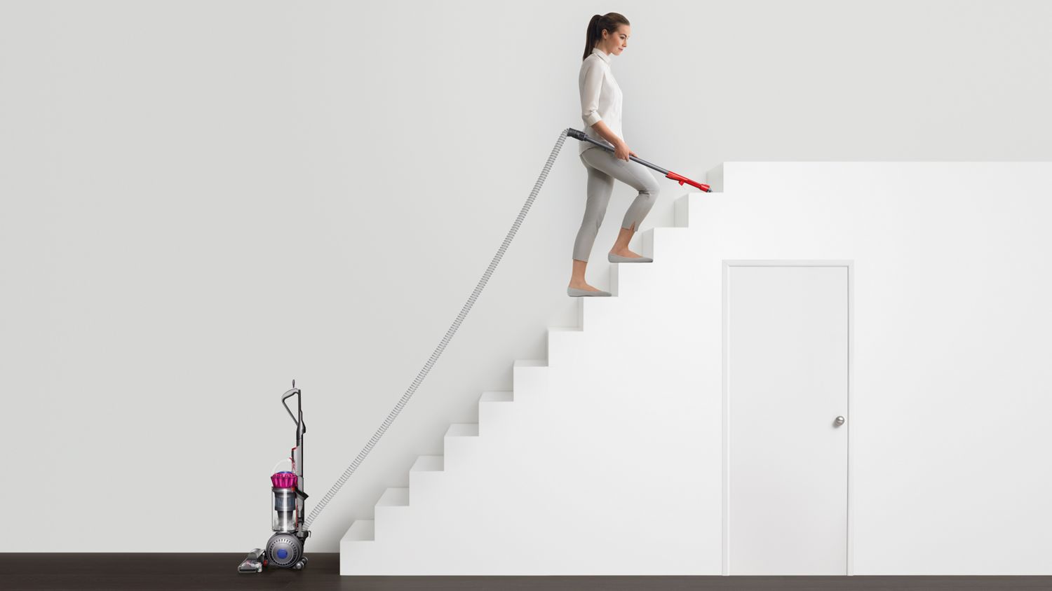 Dyson Ball Multifloor upright vacuum cleaner being used to clean stairs.