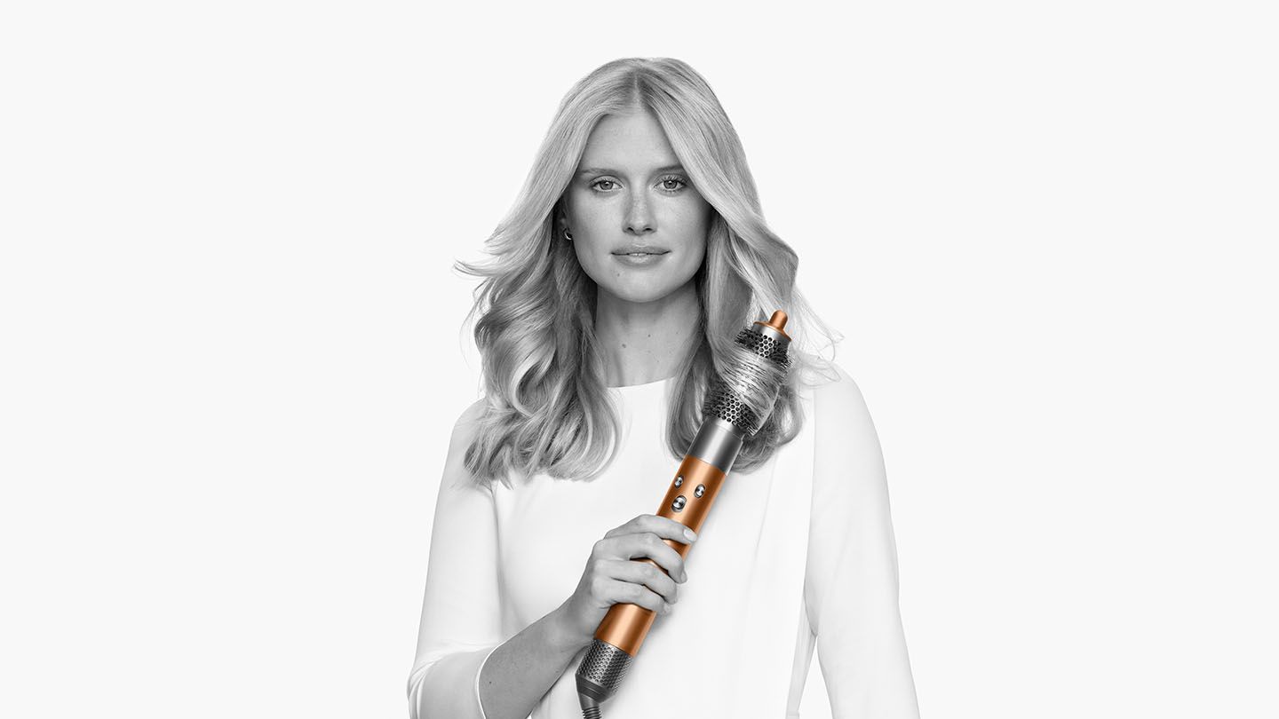 Woman curling her hair with the Dyson Airwrap Complete round brush