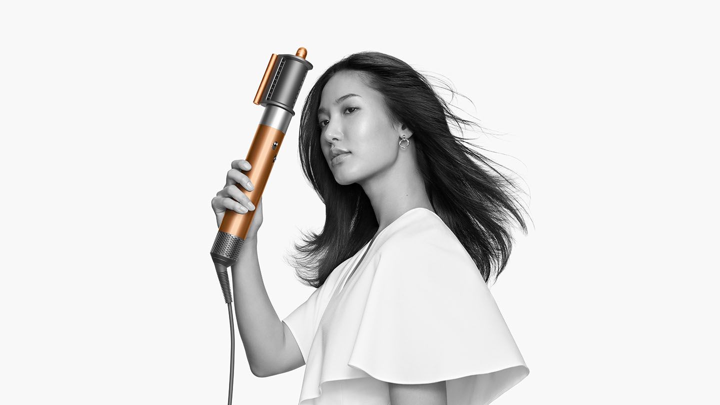Woman straightening her hair with the Dyson Airwrap Complete brush