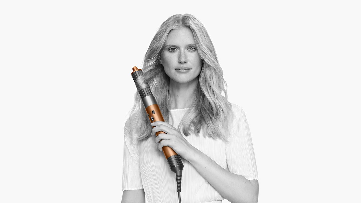Woman adding volume to her hair with the Dyson Airwrap Complete barrel