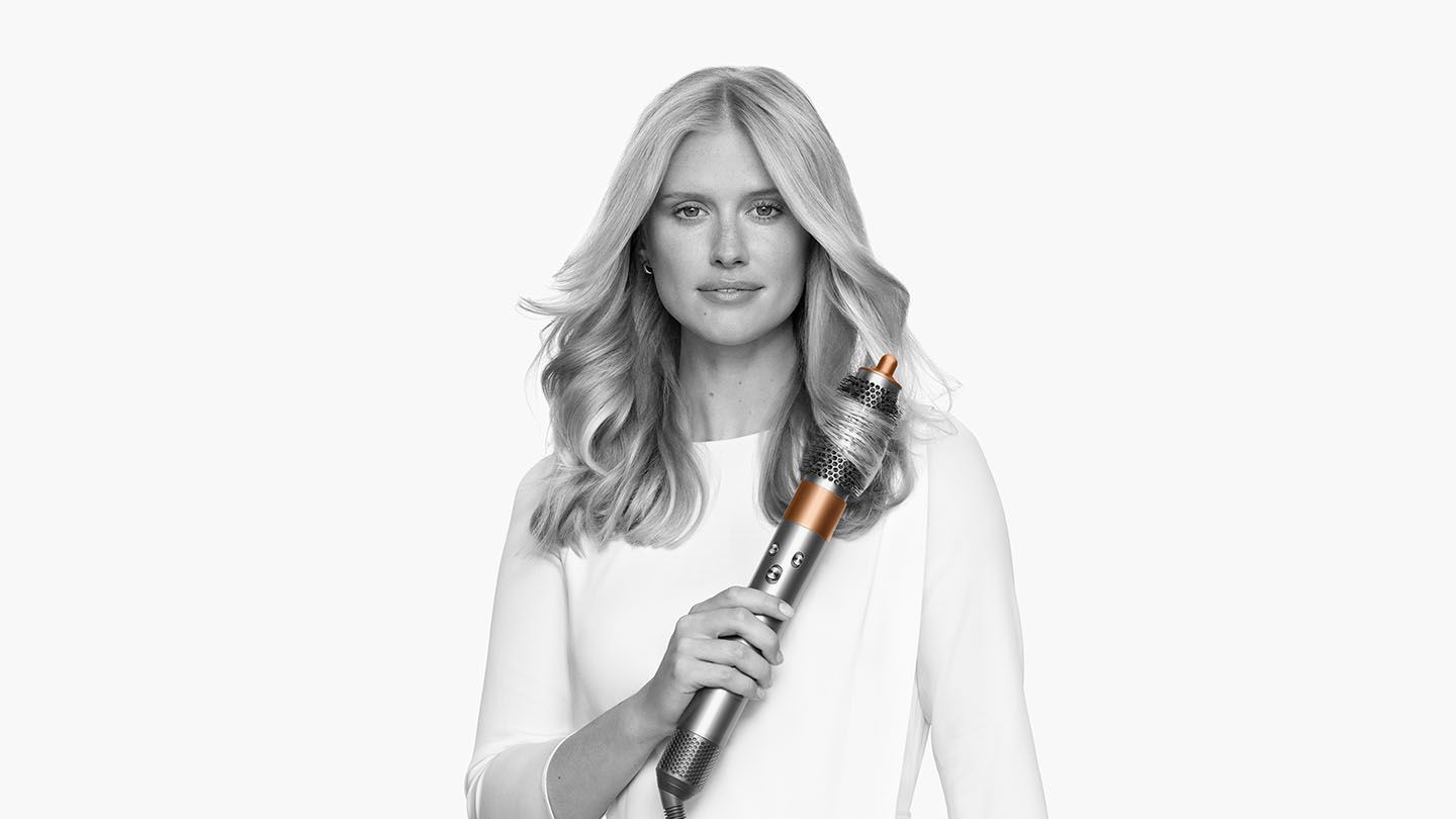 Woman curling her hair with the Dyson Airwrap Complete round brush