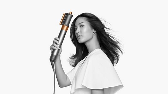 Woman drying her hair with the Dyson Airwrap Origin pre-styling dryer