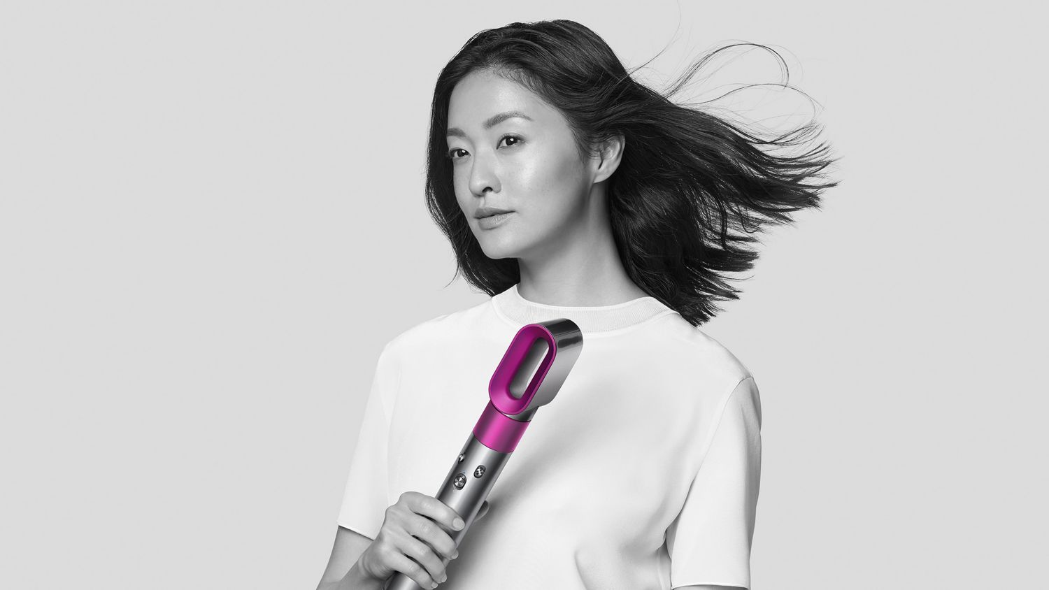 Woman using Dyson Airwrap styler with pre style dryer attached.