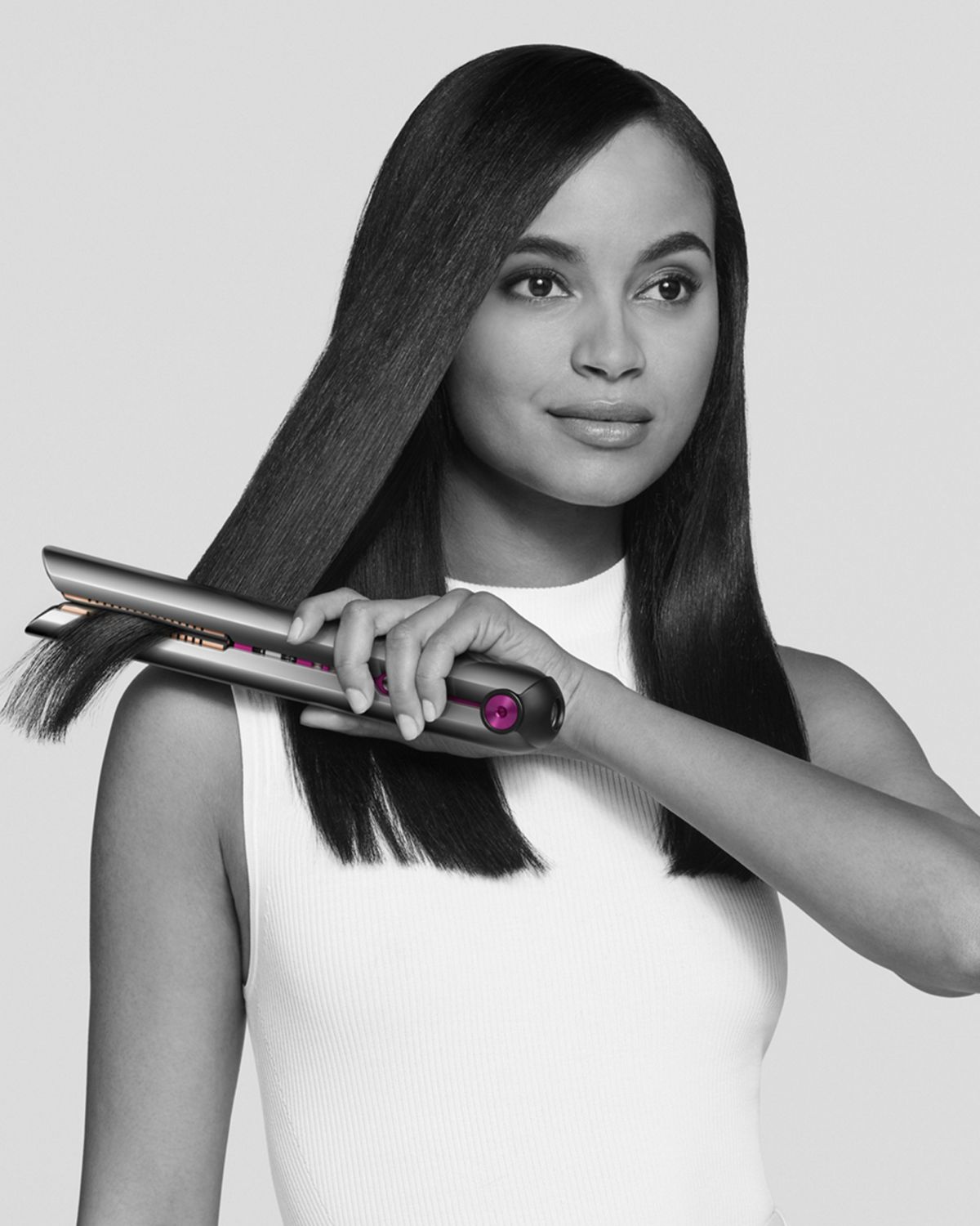 Woman using Dyson Corrale straightener.