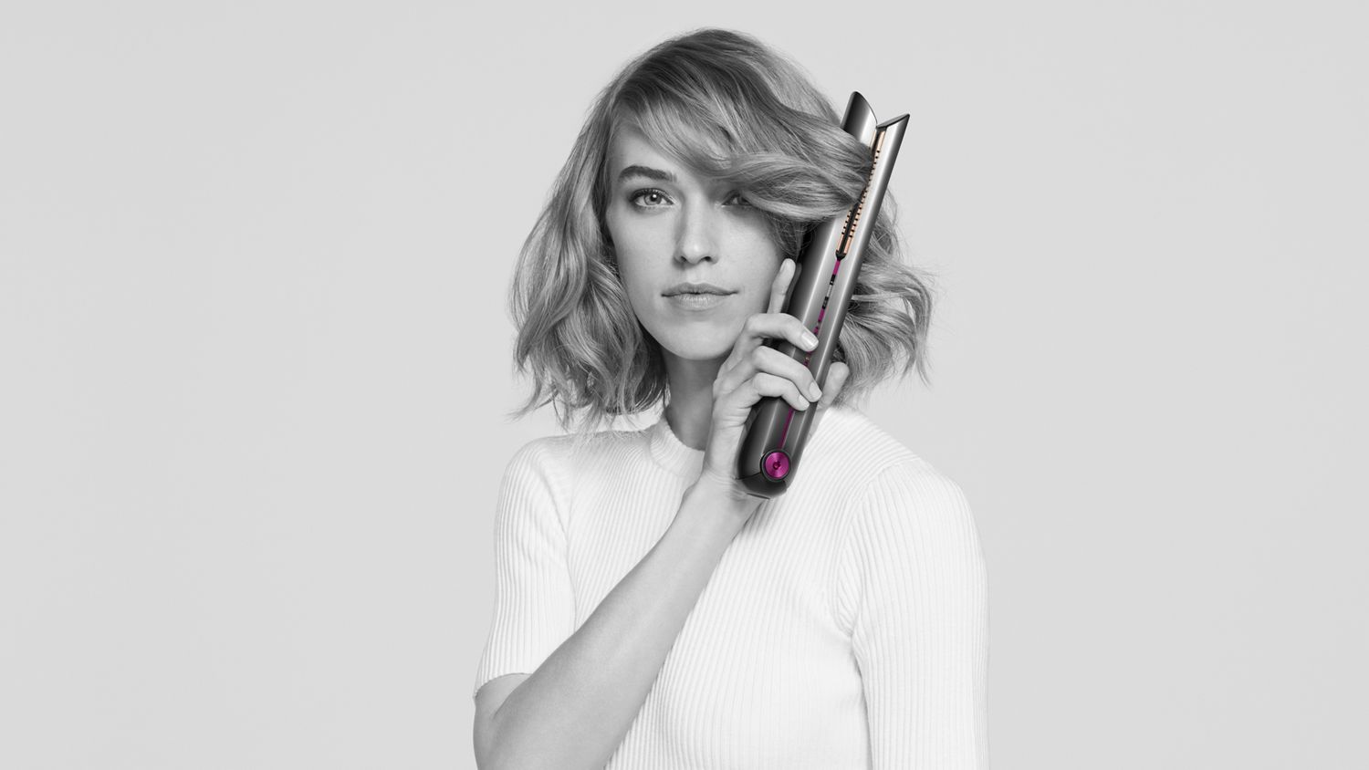 Woman using Dyson Corrale straightener.