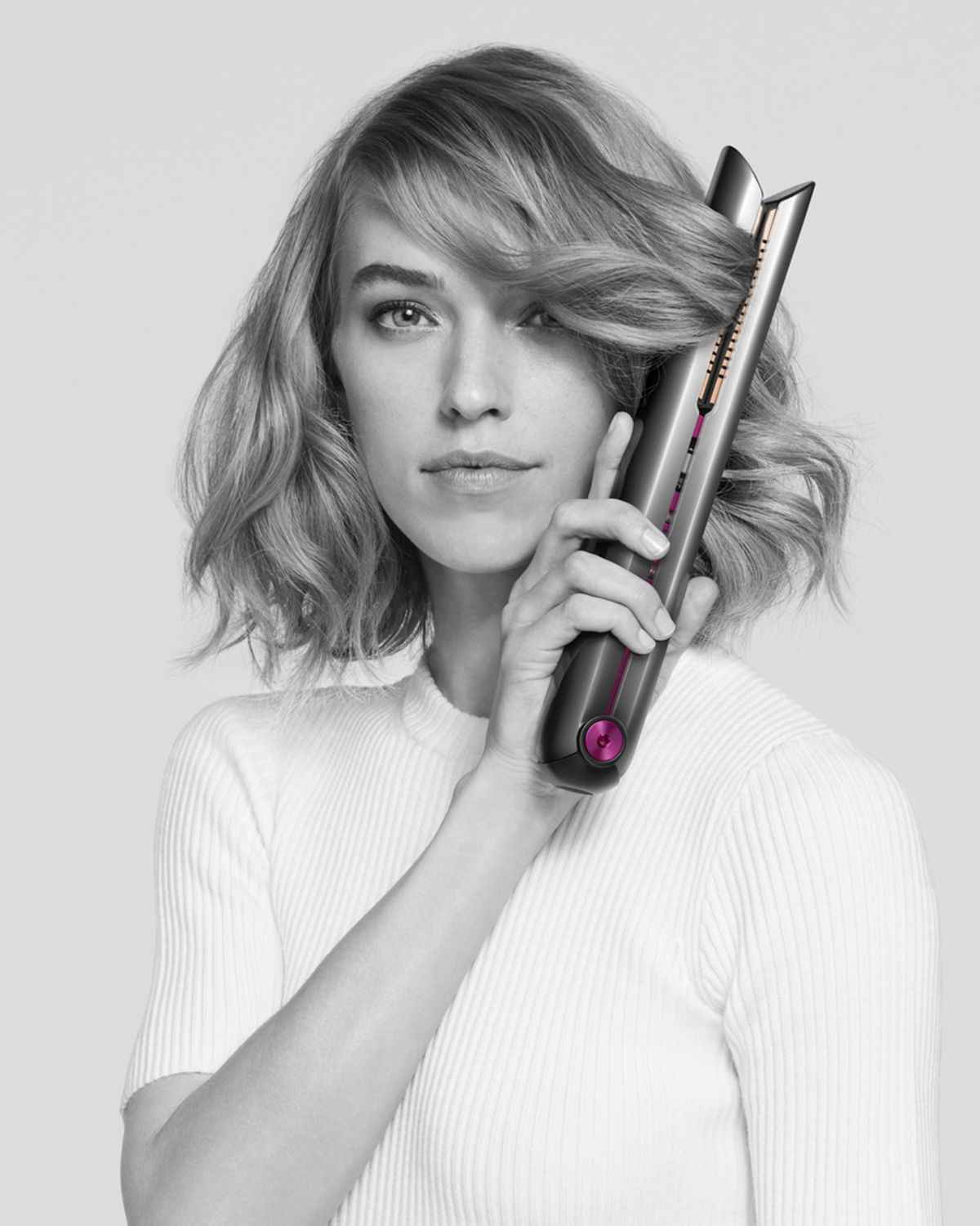 Woman using Dyson Corrale straightener.