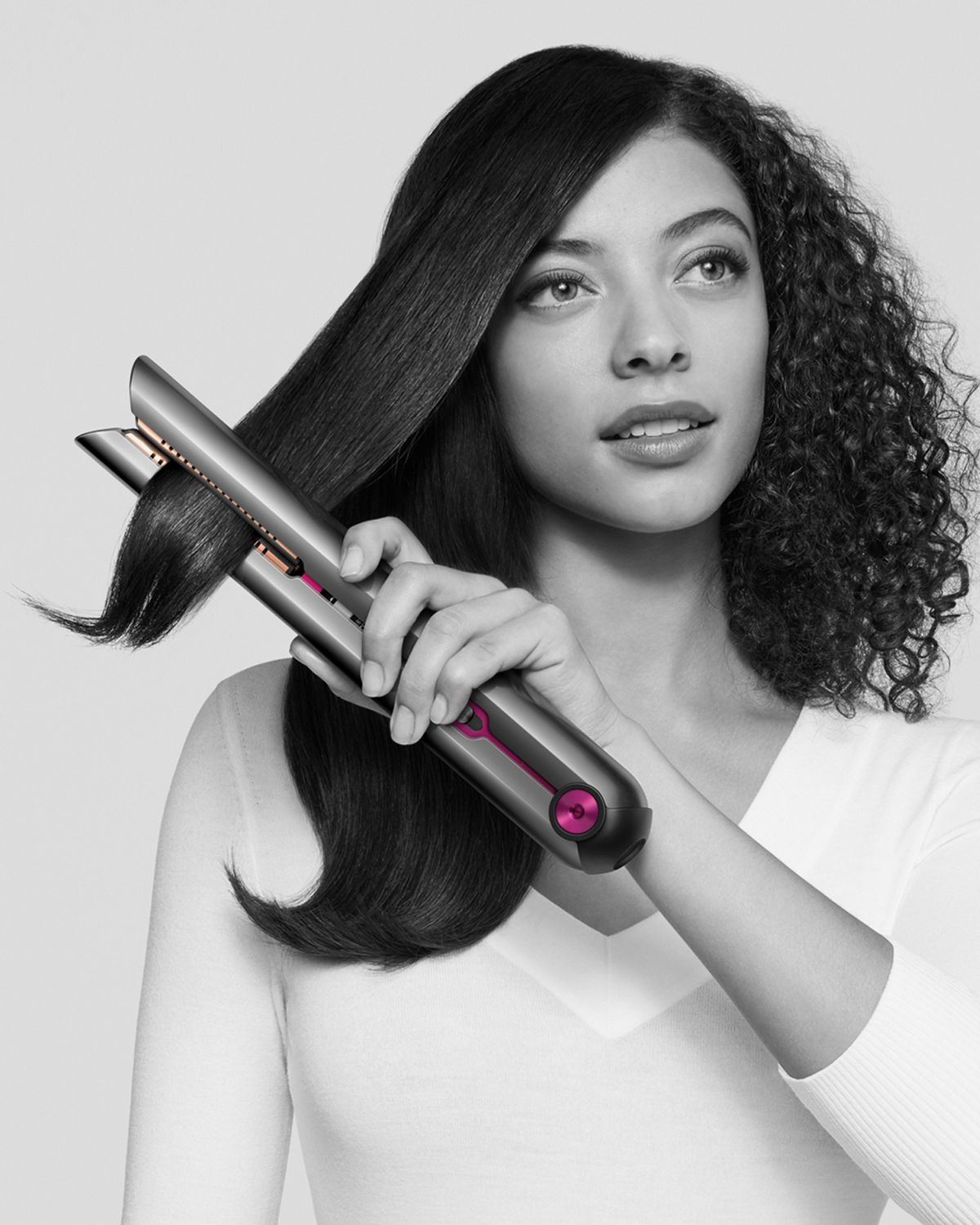 Woman using Dyson Corrale straightener.