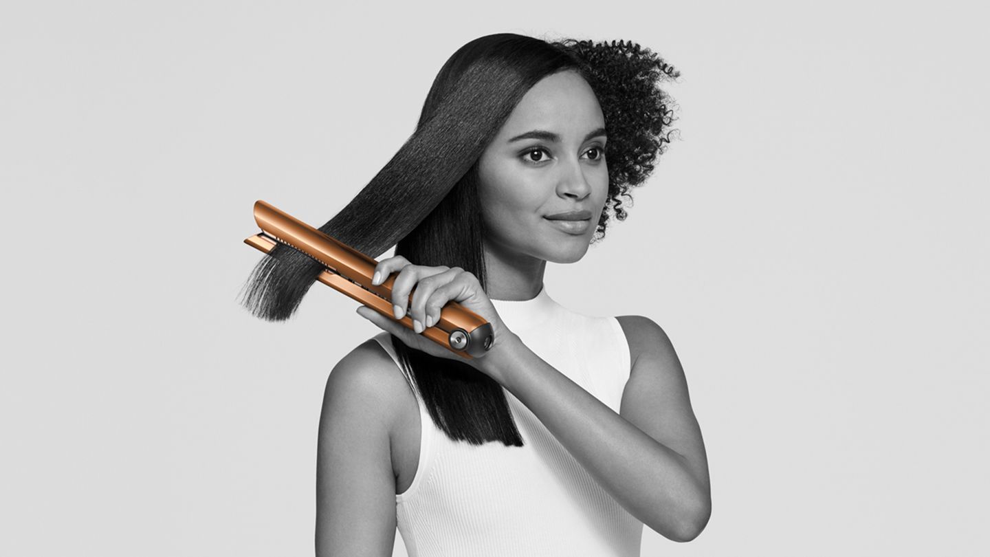 Woman using Dyson Corrale straightener.