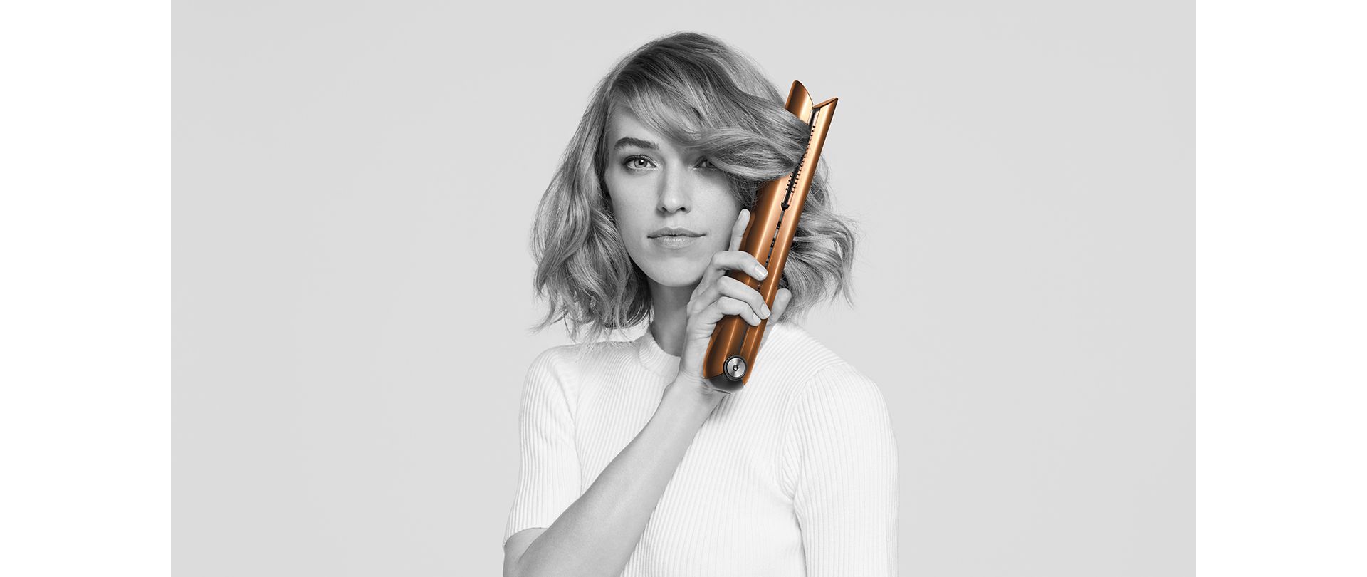 Frau mit Glätteisen für Locken