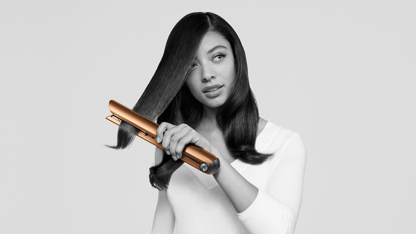 Woman using Dyson Corrale straightener.