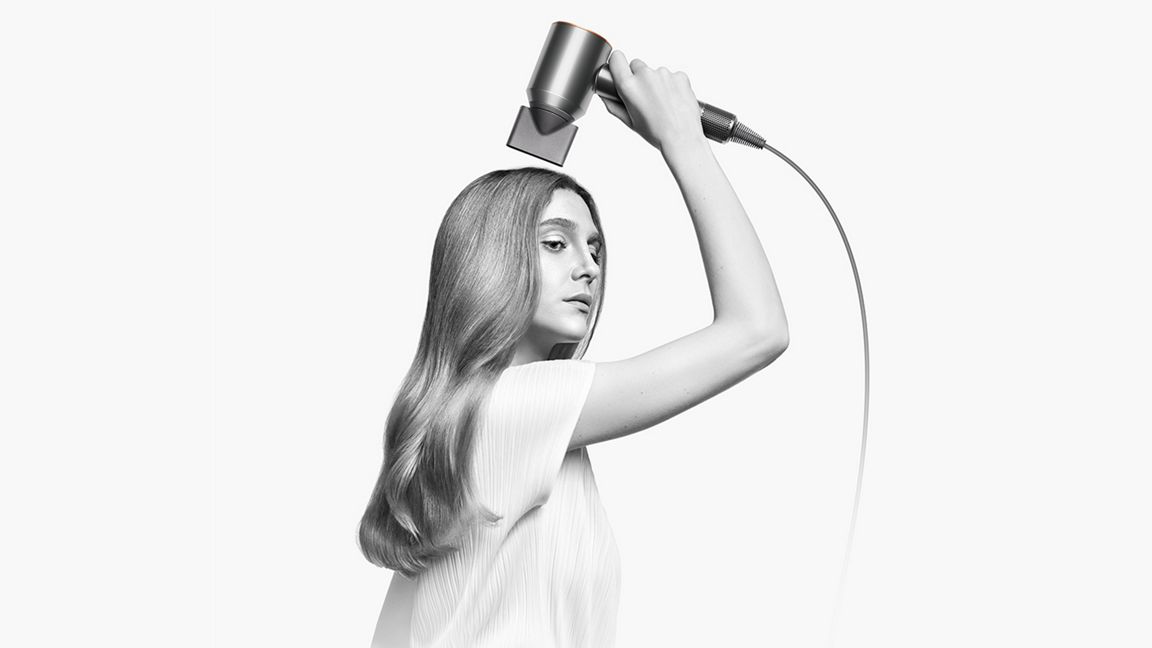 Woman using Dyson supersonic origin hair dryer