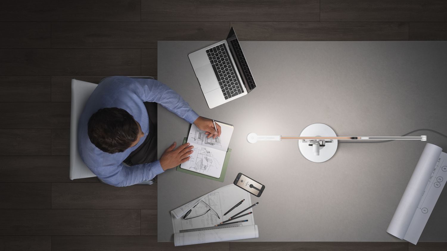 A shot from above of the Dyson Lightcycle task light illuminating a desk workspace.